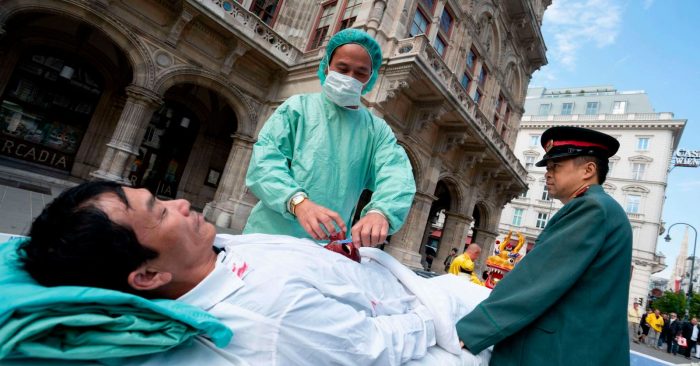 Các nhà hoạt động ở Vienna đang diễn lại cảnh mổ cướp nội tạng ở Trung Quốc, tại một sự kiện năm 2018. (Ảnh qua news.sky.com)