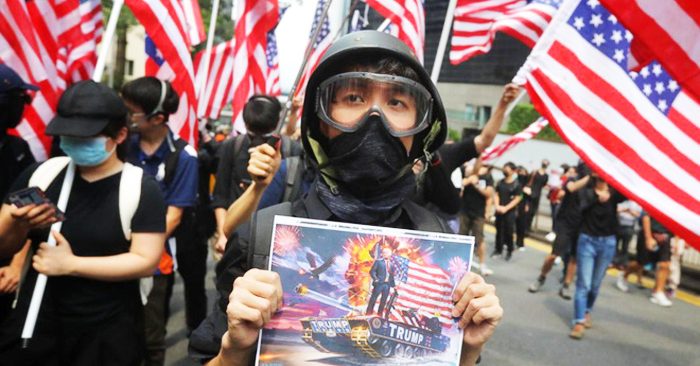 Một người biểu tình Hong Kong cầm bức ảnh Tổng thống Trump trong cuộc tuần hành trước lãnh sự quán Mỹ hôm 8/9.