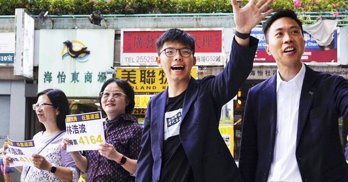 Ứng viên thắng cử của phe dân chủ Kelvin Lam và Joshua Wong vẫy tay, cám ơn sự ủng hộ của cử tri.